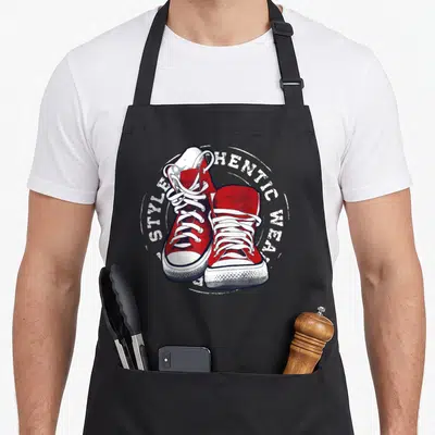 Tablier de cuisine noir avec illustration de baskets rouges authentiques style street fashion et texte circulaire blanc.