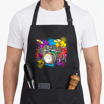 Tablier de cuisine noir avec une illustration de batterie et percussions aux couleurs vives et éclaboussures artistiques.