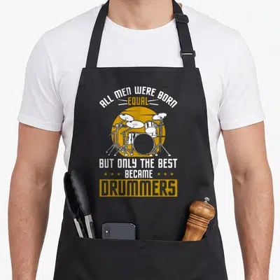 Tablier de cuisine noir avec illustration de kit de batterie et texte humoristique en anglais.