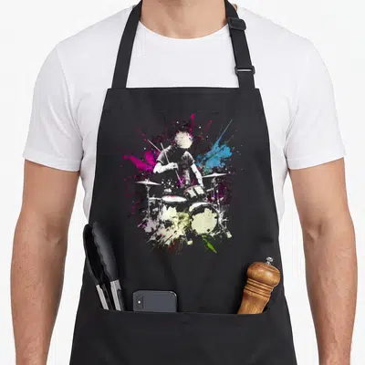 Tablier de cuisine noir avec illustration artistique d'un batteur et éclats de couleurs vives.