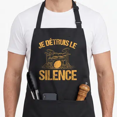 Tablier de cuisine noir avec illustration orange d'un set de batterie et le texte Je détruis le silence imprimé en lettres capitales.