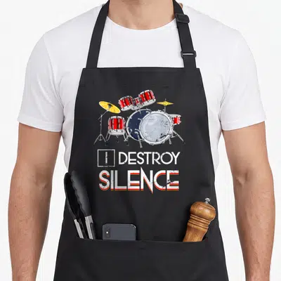 Tablier de cuisine noir avec illustration de kit de batterie rouge et texte I Destroy Silence en blanc et orange.