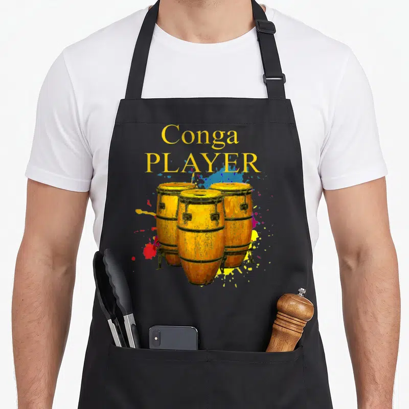Tablier de cuisine noir avec trois congas jaunes et l'inscription Conga PLAYER en lettres dorées sur fond gris uni.