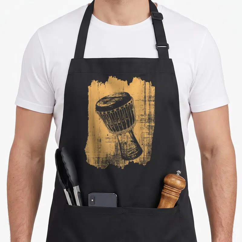 Tablier de cuisine noir avec illustration d'un tambour djembé percussion sur fond texturé orange et gris.