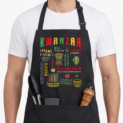 Tablier de cuisine noir avec illustration colorée de Kwanzaa, djembé, kinara et symboles culturels africains.