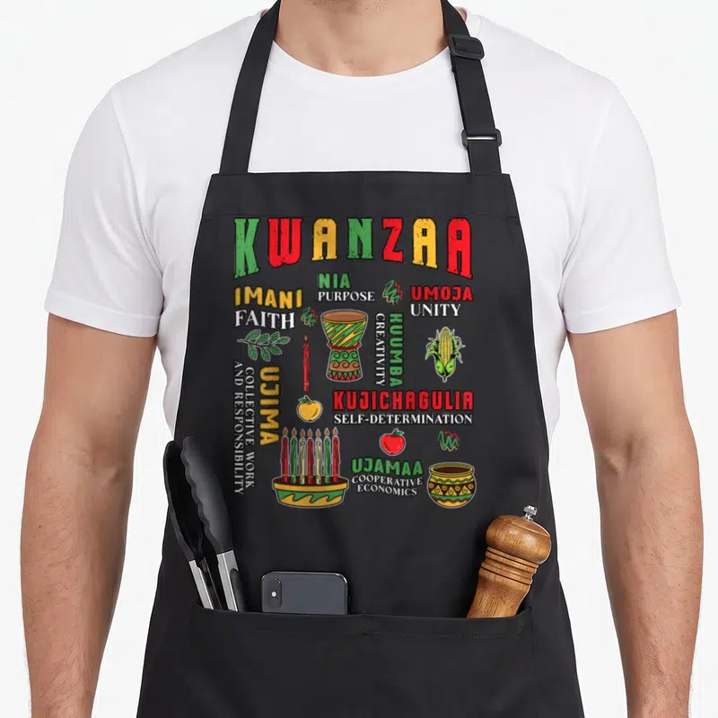 Tablier de cuisine noir avec illustration colorée de Kwanzaa, djembé, kinara et symboles culturels africains.