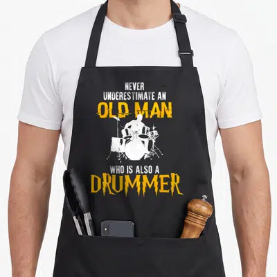 Tablier de cuisine noir avec silhouette de batteur et texte orange Never Underestimate An Old Man Drummer