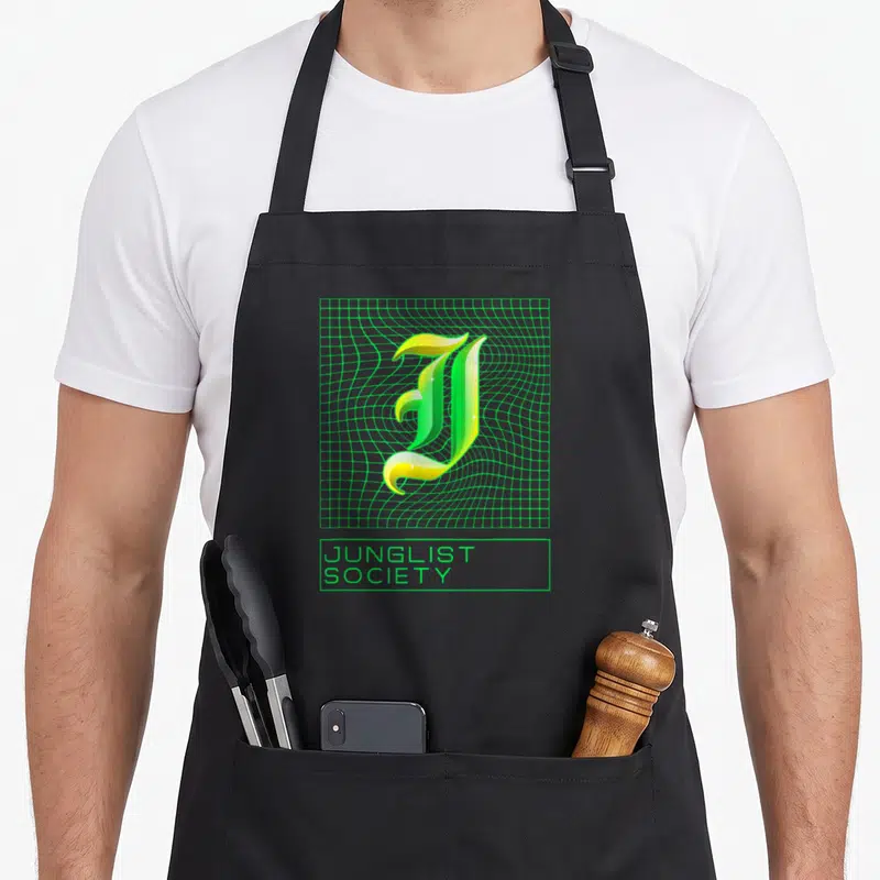 Tablier de cuisine noir avec logo Junglist Society vert et jaune sur grille ondulée style années ninety.
