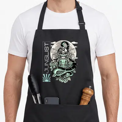 Tablier de cuisine noir avec illustration Junglist serpent, lune et fleurs vertes sur fond gris uni.
