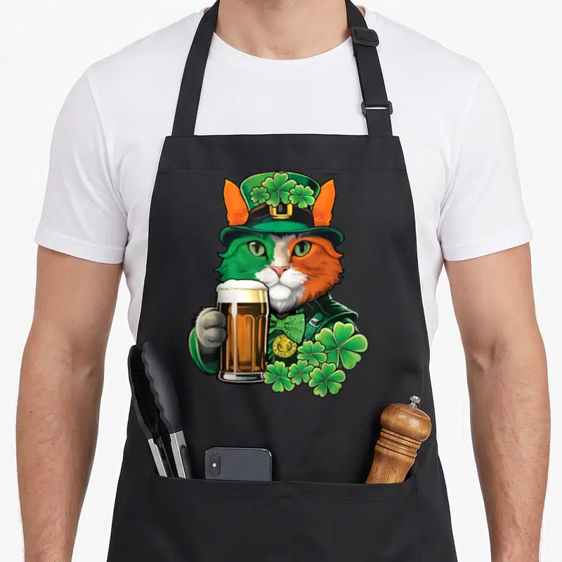 Tablier de cuisine noir avec un chat aux yeux verts et orange portant un chapeau et tenant une bière.
