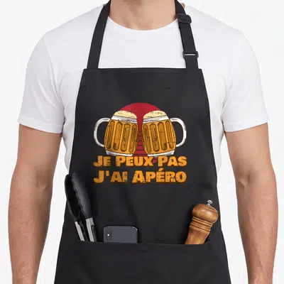 Tablier de cuisine noir avec deux verres de bière s'entrechoquant et le texte Je peux pas j'ai apéro en orange.