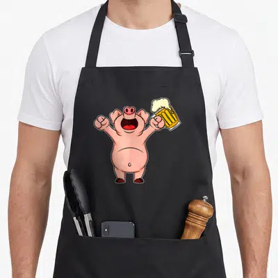 Tablier de cuisine noir avec illustration d'un cochon rose tenant un verre de bière à la mousse débordante.