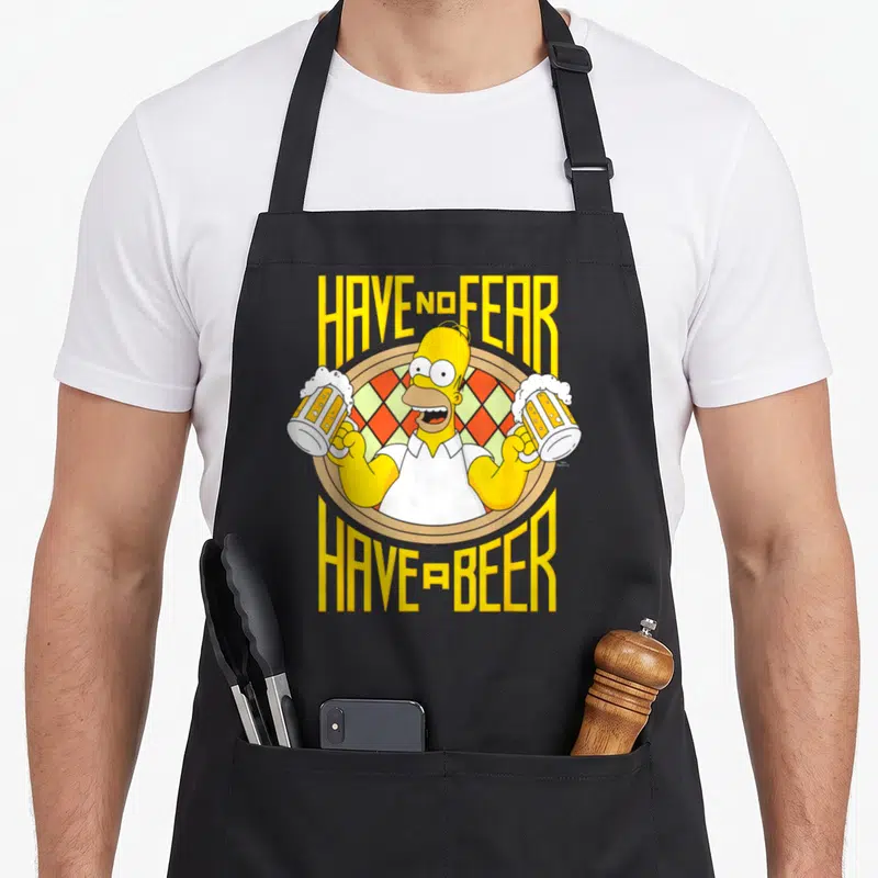 Tablier de cuisine noir avec Homer Simpson tenant deux verres de bière et le texte Have No Fear Have a Beer en lettres jaunes.