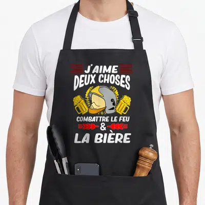 Tablier de cuisine noir avec un casque de pompier entouré de deux verres de bière et du texte J'aime deux choses combattre le feu et la bière.