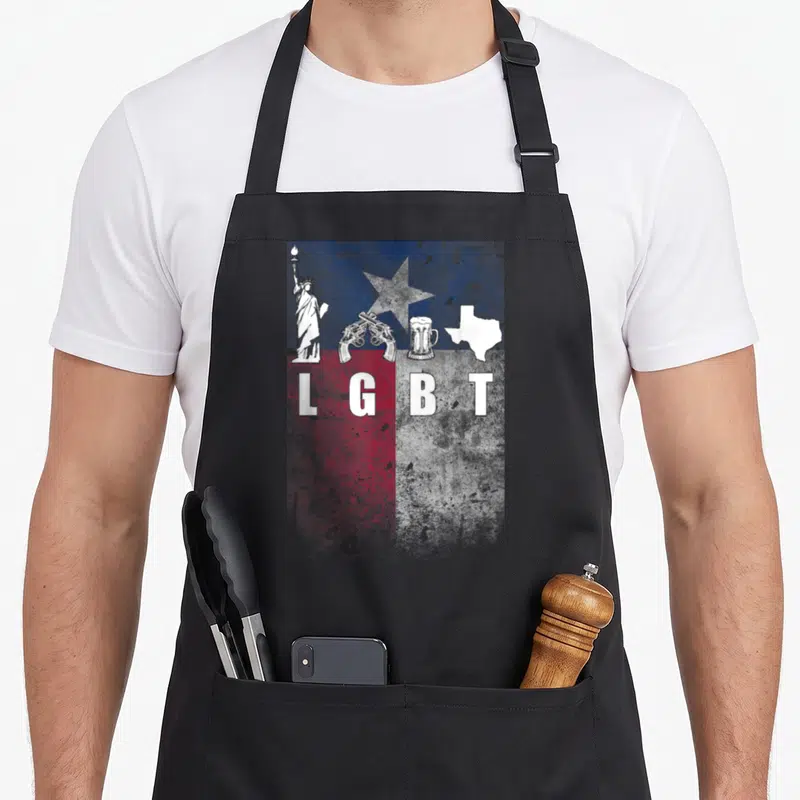 Tablier de cuisine noir avec illustration LGBT Texas incluant Statue de la Liberté, deux pistolets croisés, un verre de bière et la carte du Texas.