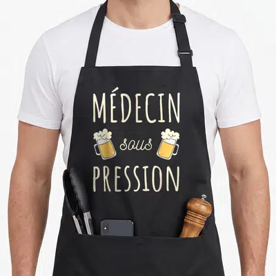 Tablier de cuisine noir avec inscription Médecin sous pression et deux verres de bière illustrés.