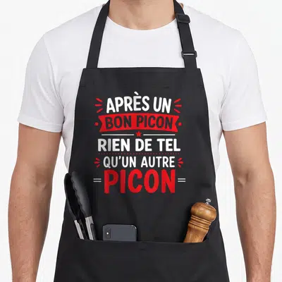 Tablier de cuisine noir avec l'inscription humoristique sur le Picon en typographie rouge et blanche stylisée.