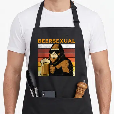 Tablier de cuisine noir avec illustration d'un gorille portant des lunettes noires et tenant une chope de bière mousseuse.