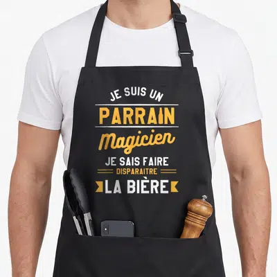 Tablier de cuisine noir avec l'inscription Je Suis Un Parrain Magicien Je Sais Faire Disparaitre La Bière en orange et blanc.