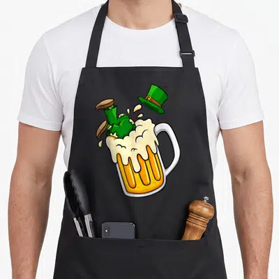 Tablier de cuisine noir avec illustration d'un leprechaun vert tombant dans une grande tasse de bière à la mousse abondante.