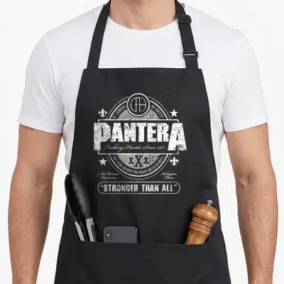 Tablier de cuisine noir avec emblème blanc Pantera Stronger Than All et détails typographiques vintage.