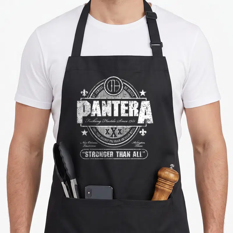 Tablier de cuisine noir avec emblème blanc Pantera Stronger Than All et détails typographiques vintage.