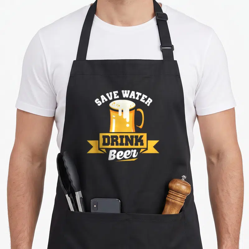 Tablier de cuisine noir avec un mug de bière doré et le texte Save Water Drink Beer en blanc et jaune.