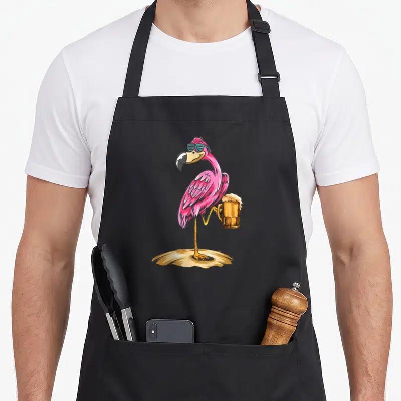 Tablier de cuisine noir avec un flamant rose portant des lunettes et tenant une chope de bière.