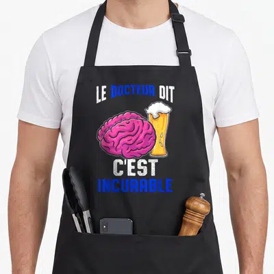 Tablier de cuisine noir avec illustration d'un cerveau rose et d'une bière dorée sur fond uni.