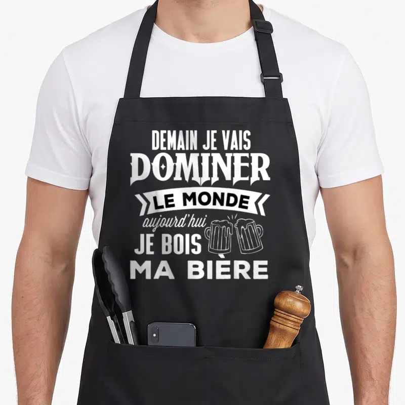 Tablier de cuisine noir avec l'inscription Demain je vais dominer le monde aujourd'hui je bois ma bière et deux verres de bière qui s'entrechoquent.