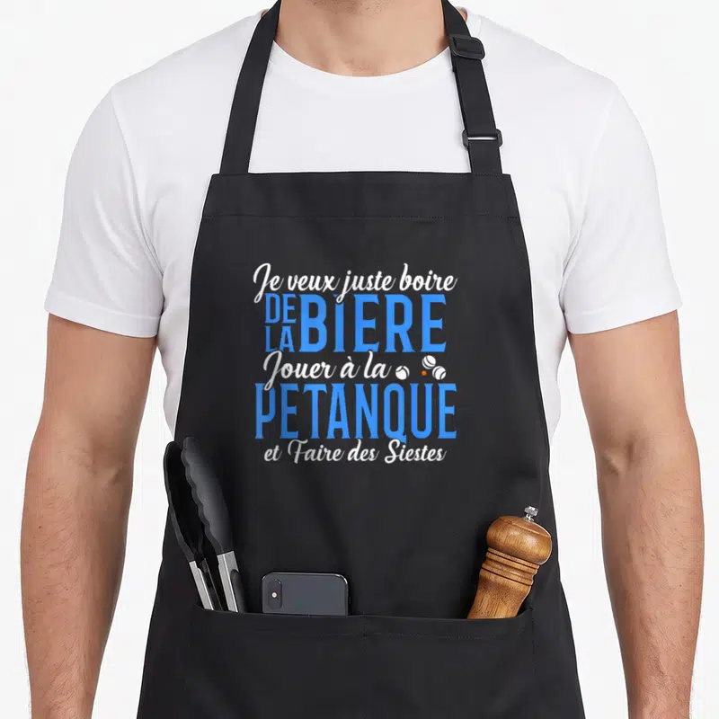 Tablier de cuisine noir avec l'inscription Je veux juste boire de la bière jouer à la pétanque et faire des siestes en typographie bleue et blanche.