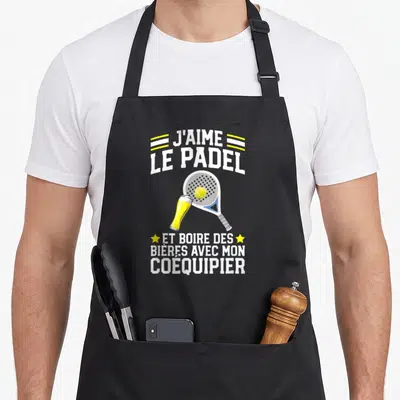 Tablier de cuisine noir avec illustration de raquette de padel, balle jaune et verre de bière sous le texte J'aime le Padel.