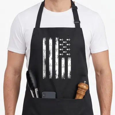 Tablier de cuisine noir avec drapeau breton blanc texturé et inscription vintage sur le devant.