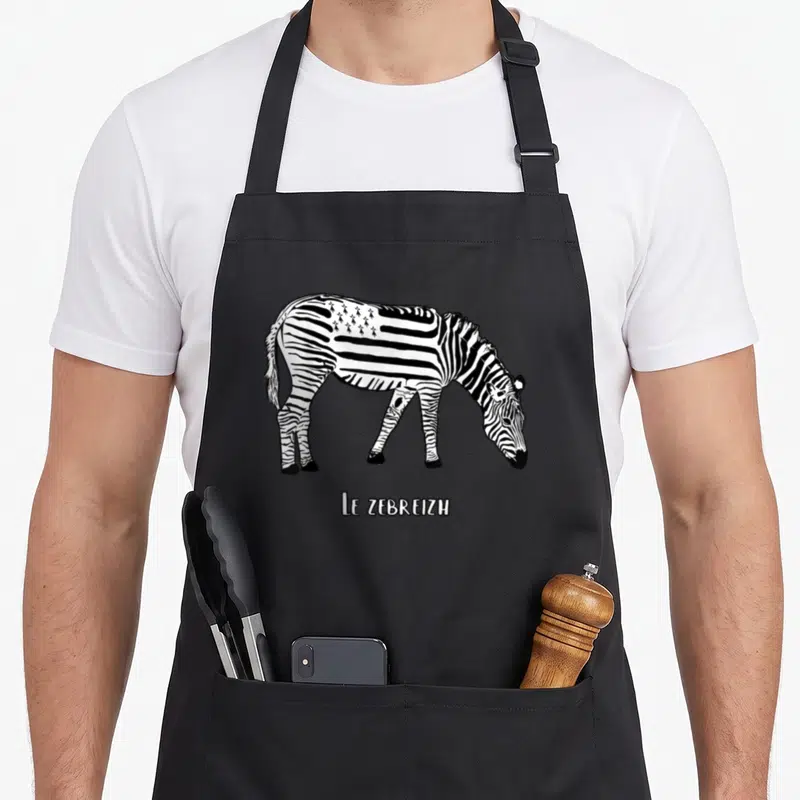 Tablier de cuisine noir avec illustration d'un zèbre aux rayures et étoiles, légende Le Zebreizh en bas.