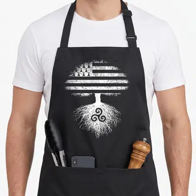 Tablier de cuisine noir avec un arbre blanc dont les branches forment un drapeau et les racines un triskèle.