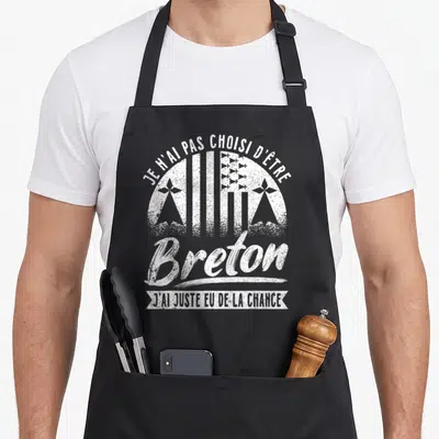 Tablier de cuisine noir avec inscription blanche Je n'ai pas choisi d'être Breton et motifs géométriques traditionnels.