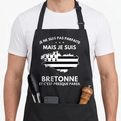 Tablier de cuisine noir avec carte de la Bretagne en drapeau et texte blanc humoristique sur l'identité locale.