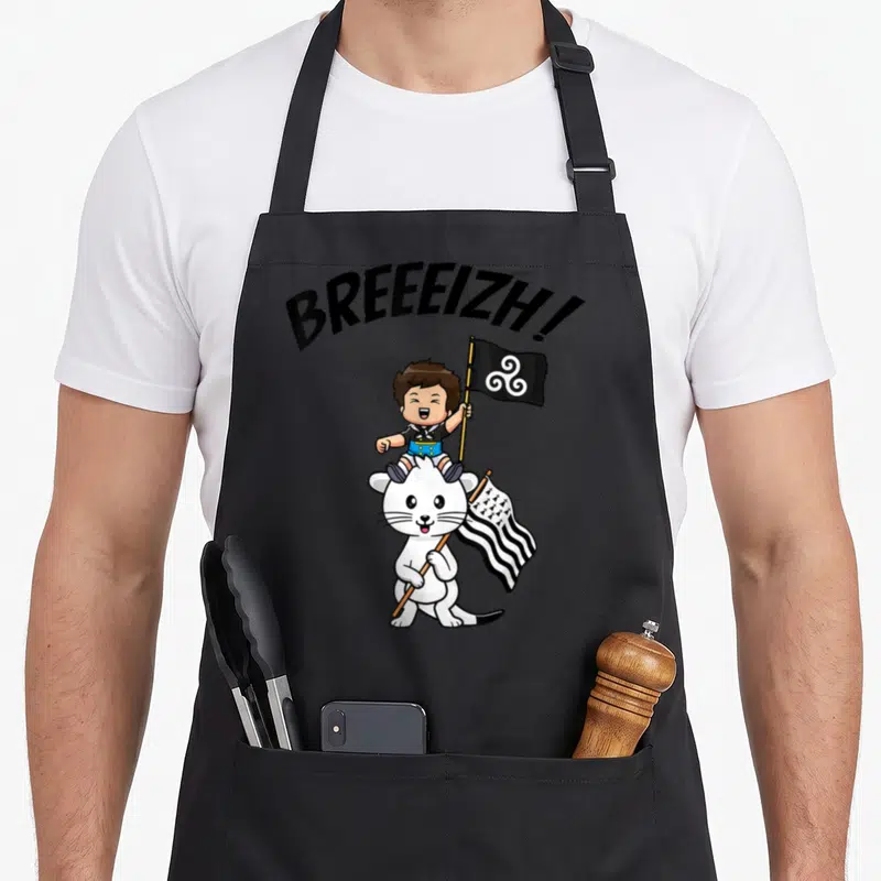 Tablier de cuisine noir avec un garçon breton sur une hermine tenant des drapeaux et le mot BREEEIZH en lettres noires.