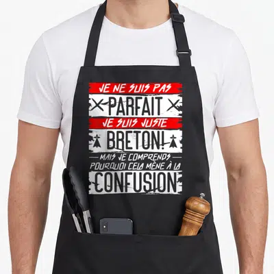 Tablier de cuisine noir avec inscription Je ne suis pas parfait je suis juste Breton en typographie grise et rouge.