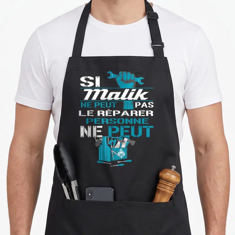 Tablier de cuisine noir avec une boîte à outils bleue et la phrase Si Malik ne peut pas le réparer personne ne peut imprimés en blanc et bleu.
