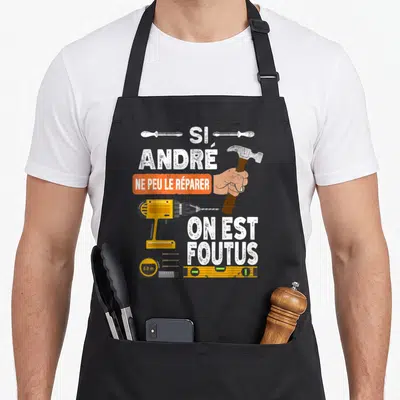 Tablier de cuisine noir avec une perceuse, un marteau et le texte Si André ne peut le réparer on est foutus.