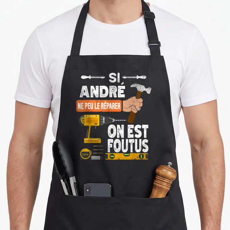 Tablier de cuisine noir avec une perceuse, un marteau et le texte Si André ne peut le réparer on est foutus.