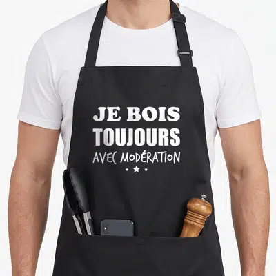 Tablier de cuisine noir avec l'inscription Je bois toujours avec modération et trois étoiles blanches sous le texte.