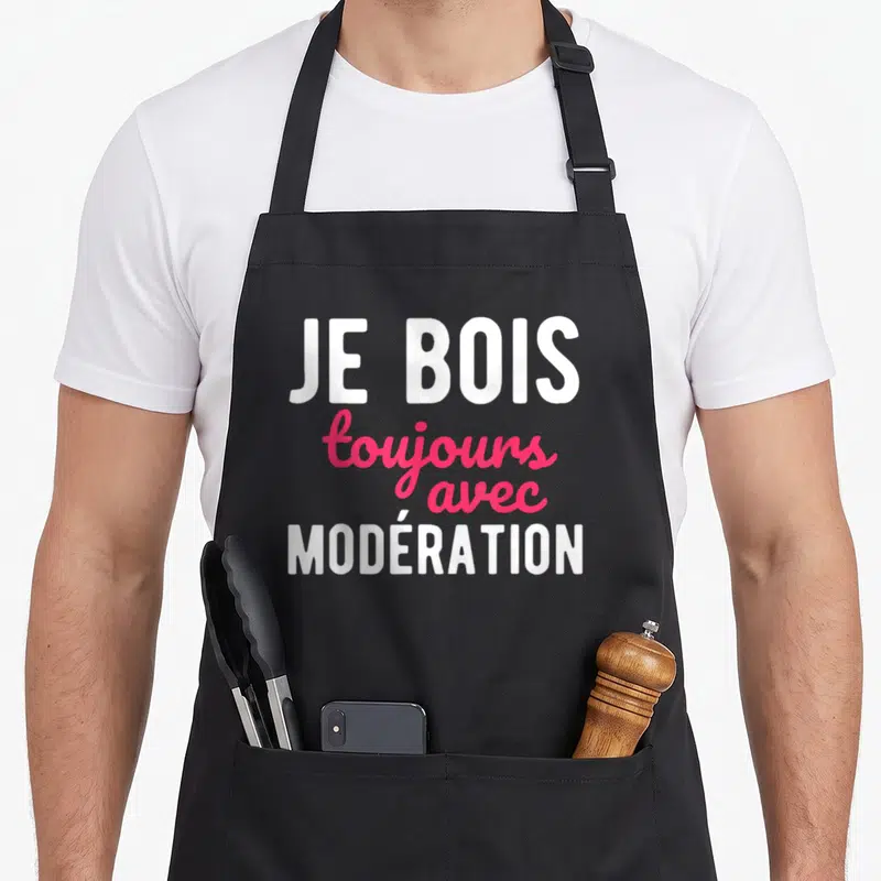 Tablier de cuisine noir avec l'inscription Je bois toujours avec modération en blanc et rose.