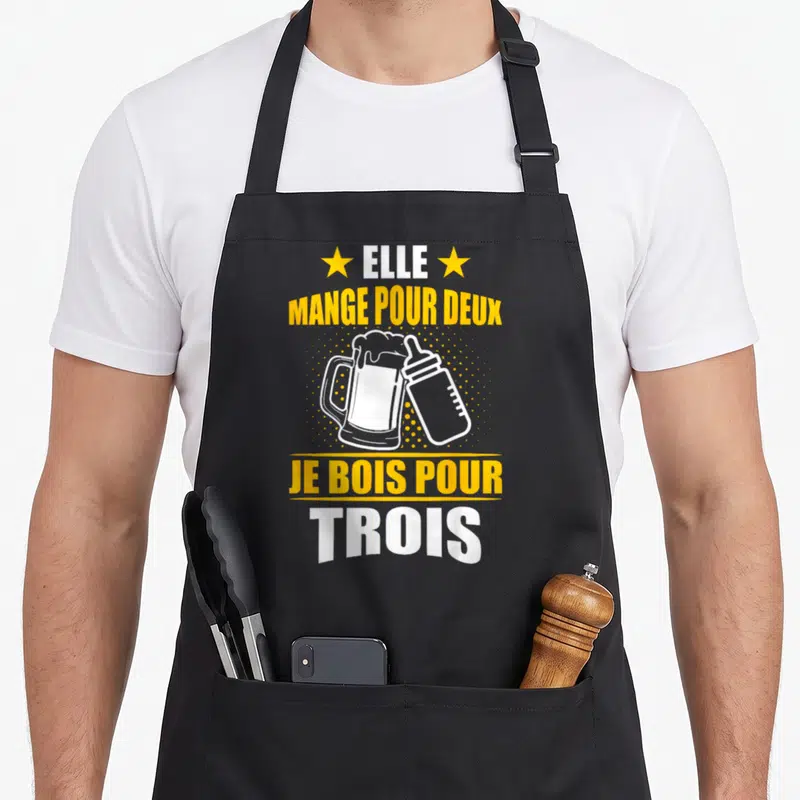Tablier de cuisine noir avec illustration d'une bière et d'un biberon et texte jaune blanc.