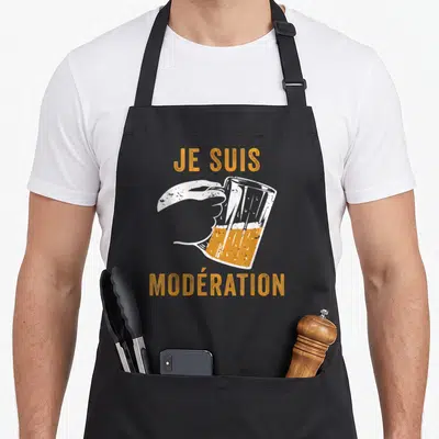 Tablier de cuisine noir avec une main blanche tenant une cruche de bière orange et le texte Je suis modération imprimé en lettres capitales.