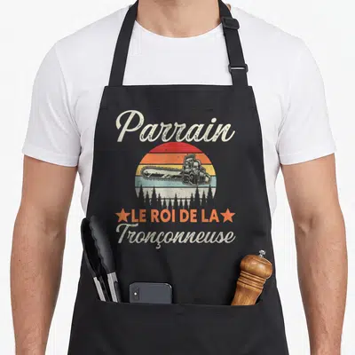 Tablier de cuisine noir avec illustration vintage d'une tronçonneuse et texte Parrain le roi de la tronçonneuse.