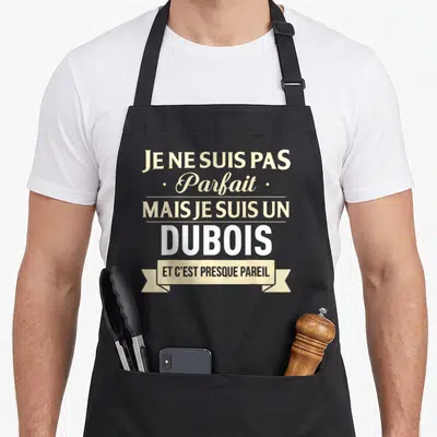 Tablier de cuisine noir avec l'inscription Je ne suis pas Parfait mais je suis un Dubois et c'est presque pareil en typographie beige et blanche.