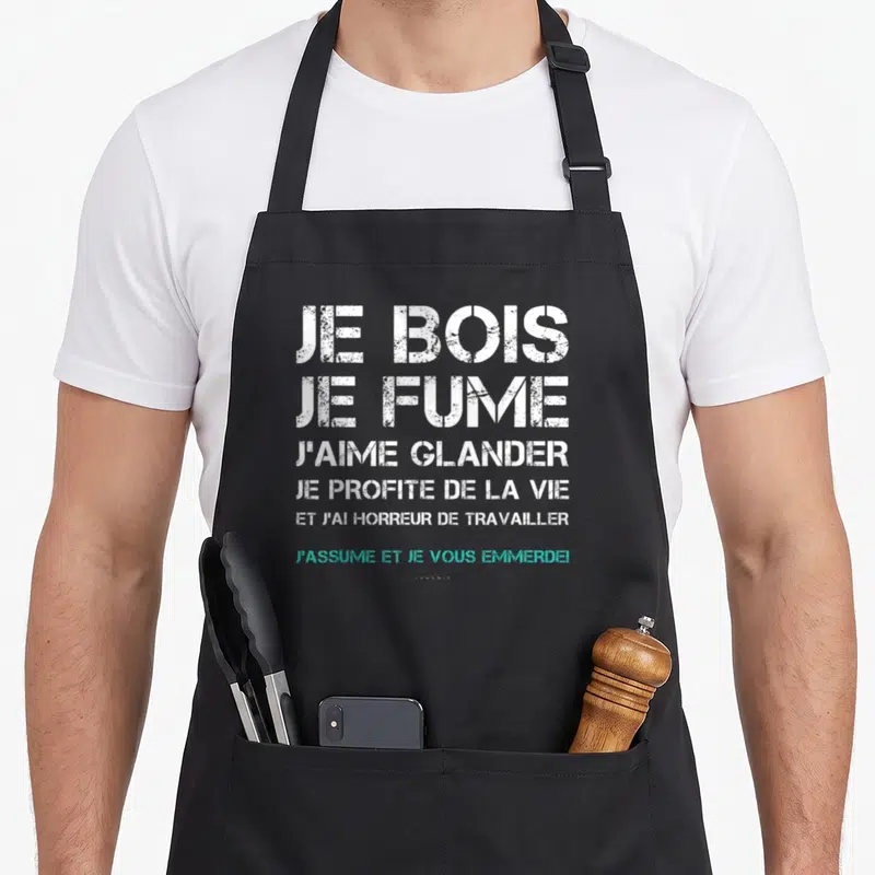 Tablier de cuisine noir avec le texte blanc et turquoise Je bois je fume j'aime glander imprimé au centre.