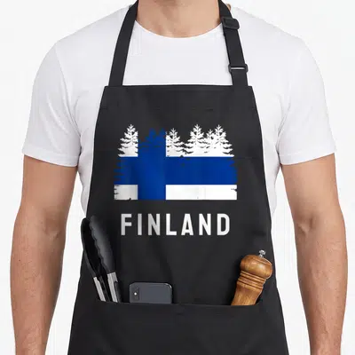 Tablier de cuisine noir avec drapeau forêt finlandaise et inscription Finland en lettres blanches capitales.
